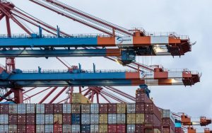 Cranes loading cargo containers at Hamburg's shipping port.